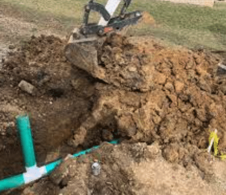 Plumber backfilling trench